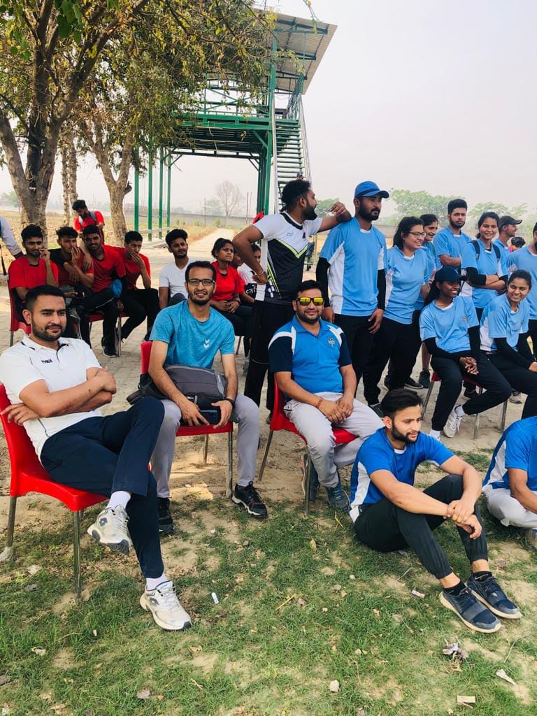 Youth athletes in red/blue jerseys at outdoor sports ground